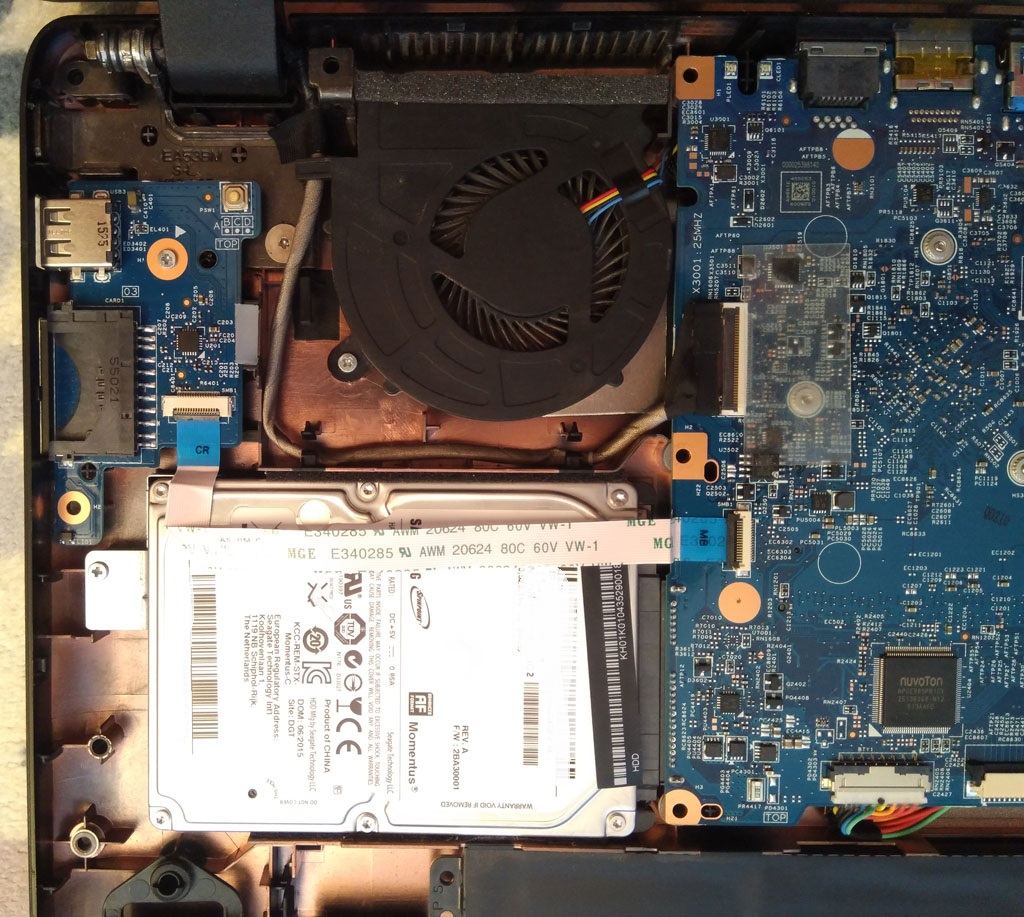 Vnitřek rozebraného notebooku po sejmutí spodního krytu — chladicí ventilátor s heatpipe, 2,5″ HDD, IO daughterboard a hlavní motherboard