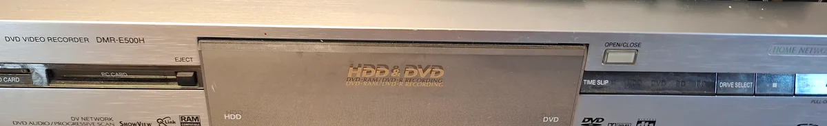 Oříznutý detail čelního panelu Panasonic DMR-E500H s označením HDD a DVD