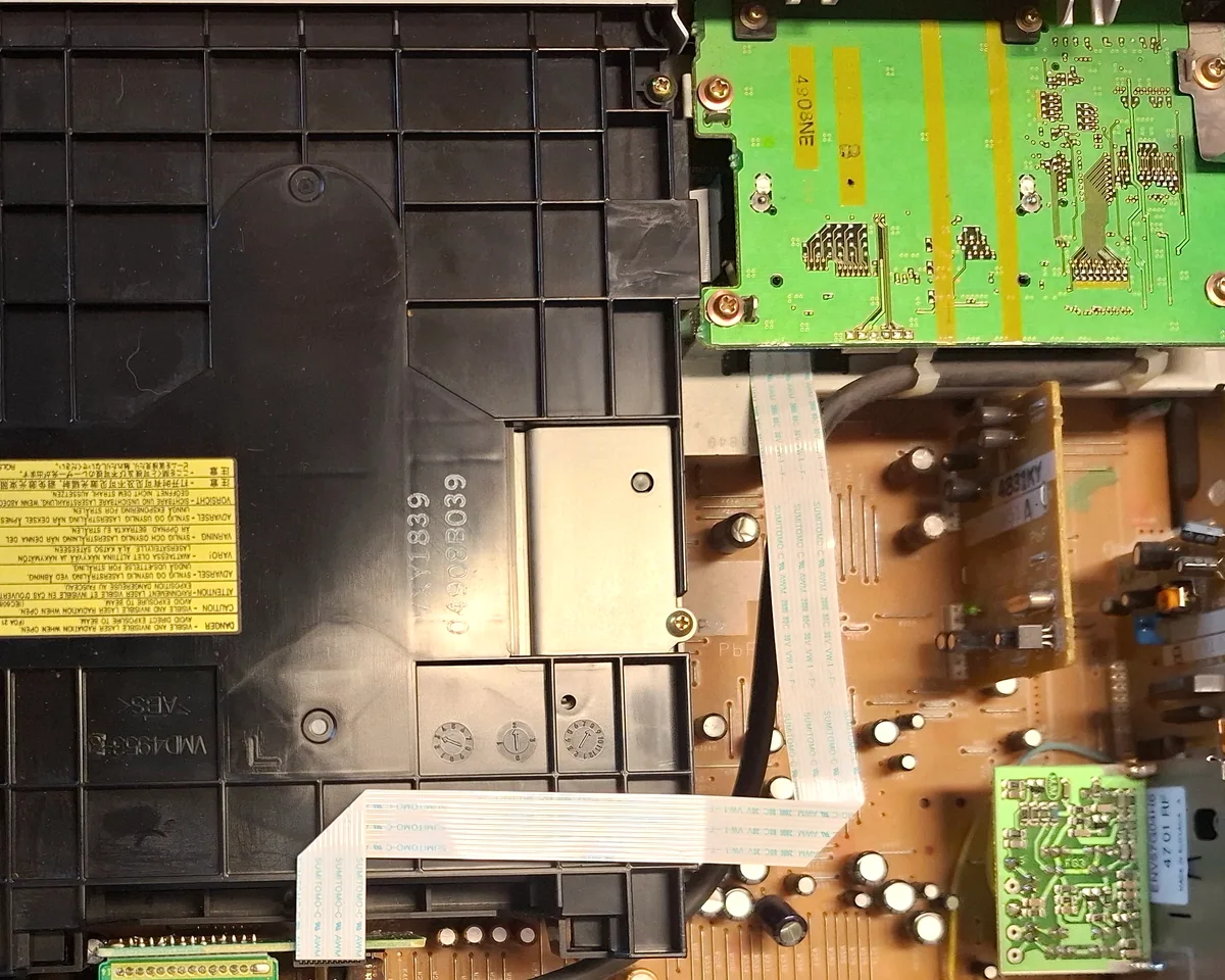 Detail skutečného vnitřku Panasonic DMR-E500H: desky elektroniky, kryt mechaniky a ploché kabely