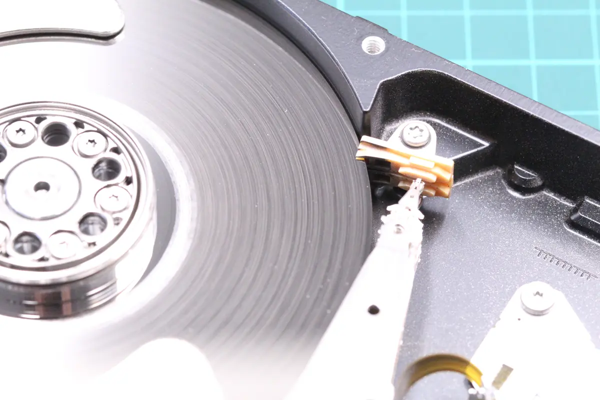 Detaillierte Makroaufnahme der beschädigten Head-Stack-Assembly der Festplatte Seagate ST2000DM001 — verbogene Arme sichtbar