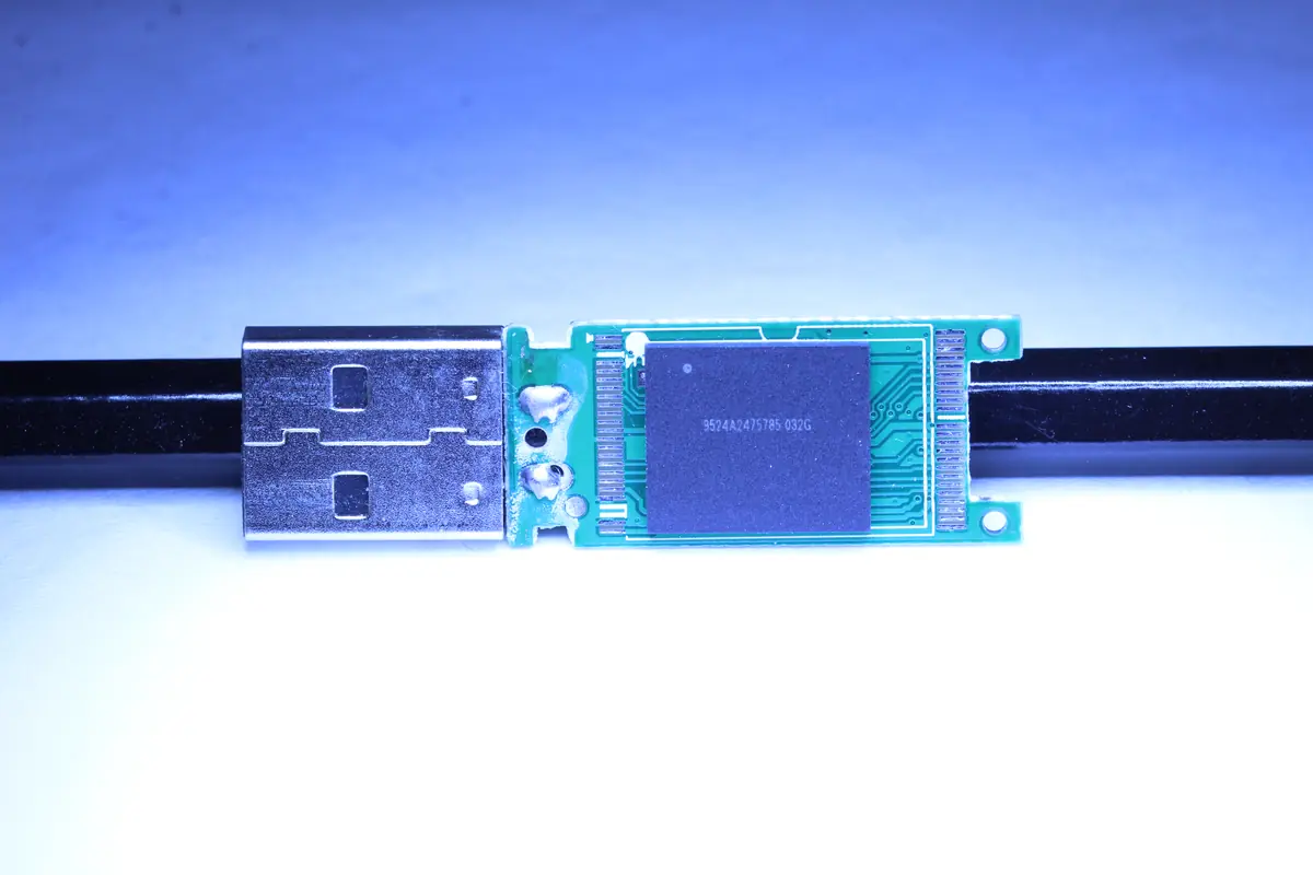 USB flash drive after chip-off — the removed NAND chip ready for reballing and reading via PC3000 Flash