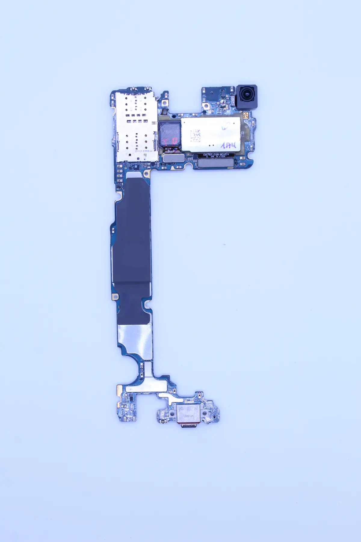 Mainboard des Samsung Galaxy S10 nach der Entnahme — Detailaufnahme der Korrosion rund um die Stromversorgungssektion und den PMIC-Chip