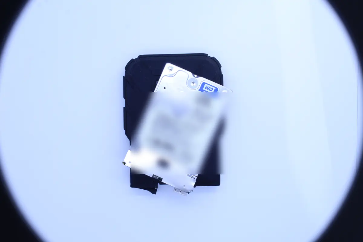 Western Digital Blue 2,5 palcový pevný disk se zavřeným krytem na černé podložce, nasvícený kruhovým ringlight při příjmové prohlídce